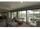 Relaxing sunroom with wicker seating, large sliding glass doors, and tranquil views of the outdoor landscape at 1335 Eureka Mill Run, The Villages, FL 32162