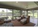 Bright sunroom with comfortable seating, large windows, and scenic views of the well-maintained yard at 1335 Eureka Mill Run, The Villages, FL 32162