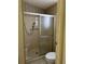 Bathroom shower and toilet, featuring a glass door enclosure and beige colored walls at 1404 Plantation Dr # 9, Lady Lake, FL 32159