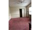 Spacious bedroom with ceiling fan, closet, and red carpet at 1404 Plantation Dr # 9, Lady Lake, FL 32159