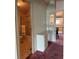Hallway with built-in drawers and decorative glass, leading to a bathroom with a tub-shower at 1404 Plantation Dr # 9, Lady Lake, FL 32159