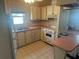 The kitchen has cream cabinets, a window view, and neutral flooring at 1404 Plantation Dr # 9, Lady Lake, FL 32159