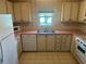 Kitchen with cream cabinets, neutral counters, appliances, and a window view at 1404 Plantation Dr # 9, Lady Lake, FL 32159