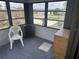 Enclosed patio with black framed windows offering neighborhood views and a plastic chair at 1404 Plantation Dr # 9, Lady Lake, FL 32159