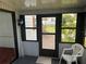 Enclosed patio with a plastic chair, black framed windows, and an exterior view at 1404 Plantation Dr # 9, Lady Lake, FL 32159