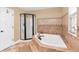 Relaxing bathroom featuring a luxurious jacuzzi tub, separate shower, and elegant tile design at 1436 Spring Lake Rd, Fruitland Park, FL 34731