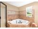 Bright bathroom with a jacuzzi tub, corner shower, and a window offering a pleasant view at 1436 Spring Lake Rd, Fruitland Park, FL 34731