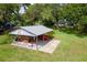 Spacious open carport with a concrete pad, shelter with corrugated metal roof, and a tractor for equipment storage at 1436 Spring Lake Rd, Fruitland Park, FL 34731