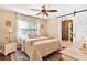 Bright bedroom with a ceiling fan, en-suite bathroom, and large windows offering plenty of natural light at 1436 Spring Lake Rd, Fruitland Park, FL 34731