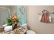 Well-lit bathroom features a granite countertop, decorative wall art, and fresh flowers for a cozy ambiance at 1664 Vinewood Ave, The Villages, FL 32162