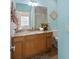 Bathroom featuring a wood vanity, granite counter, framed mirror, and shower with glass door at 1664 Vinewood Ave, The Villages, FL 32162