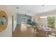 Bright dining area with modern chandelier, leading to a cozy living space and patio with a view of the outdoors at 1664 Vinewood Ave, The Villages, FL 32162