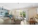 Elegant dining area with a modern chandelier, comfortable seating, and seamless connection to the outdoor patio and living space at 1664 Vinewood Ave, The Villages, FL 32162