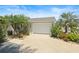 Single-Gathering home with palm trees and flowering plants highlighting the entryway at 1664 Vinewood Ave, The Villages, FL 32162