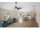 Open-concept living area featuring modern ceiling fan, dining space, kitchen, comfortable seating, and ample natural light at 1664 Vinewood Ave, The Villages, FL 32162