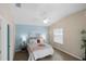 Comfortable bedroom with ceiling fan, blue accent wall, and ample natural light from the window at 1664 Vinewood Ave, The Villages, FL 32162