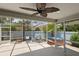 Screened porch featuring a spa, ceiling fan, lounge area, and beautiful outdoor views at 1664 Vinewood Ave, The Villages, FL 32162