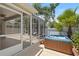 Enclosed patio features a hot tub, outdoor seating, and views of the well-maintained yard at 1664 Vinewood Ave, The Villages, FL 32162