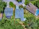 An aerial view shows the layout of a house with an elongated roof and mature trees on a large corner lot at 17037 Se 76Th Creekside Cir, The Villages, FL 32162