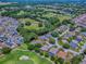 An aerial view showcases a community home on a golf course with lush greenery and serene water features at 17037 Se 76Th Creekside Cir, The Villages, FL 32162