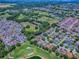 An aerial view showcases a community home on a golf course with lush greenery and serene water features at 17037 Se 76Th Creekside Cir, The Villages, FL 32162