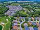 An aerial view showcases a community home on a golf course with lush greenery and serene water features at 17037 Se 76Th Creekside Cir, The Villages, FL 32162