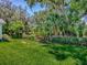 Spacious backyard with a wooden fence, mature trees, and lush green grass at 17037 Se 76Th Creekside Cir, The Villages, FL 32162