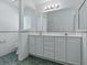 Bathroom featuring double sinks and a large mirror over white cabinets at 17037 Se 76Th Creekside Cir, The Villages, FL 32162