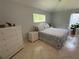 Bedroom features a stylish dresser, a comfortable bed, and serene views at 17037 Se 76Th Creekside Cir, The Villages, FL 32162