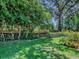 Green backyard featuring an open lawn, and mature landscaping at 17037 Se 76Th Creekside Cir, The Villages, FL 32162