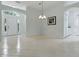Open-concept living room with neutral tile flooring, arched doorways, and a view of the front entrance at 17037 Se 76Th Creekside Cir, The Villages, FL 32162