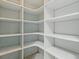 Walk-in pantry with ample white shelving for optimal storage and organization at 17037 Se 76Th Creekside Cir, The Villages, FL 32162