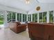 Relaxing sunroom with tile floors, vaulted ceiling, large windows, and comfortable seating at 17037 Se 76Th Creekside Cir, The Villages, FL 32162