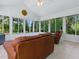 Bright sunroom with tile floors and a vaulted ceiling features large windows with views of the lush, mature landscaping at 17037 Se 76Th Creekside Cir, The Villages, FL 32162
