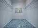 Spacious walk-in closet with metal shelving and blue tile flooring at 17037 Se 76Th Creekside Cir, The Villages, FL 32162