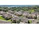 Aerial view of a community featuring townhomes with well-manicured lawns and palm tree-lined streets at 17439 Promenade Dr, Clermont, FL 34711
