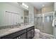 Luxurious bathroom with double sinks, granite countertops, and a glass-enclosed shower at 17439 Promenade Dr, Clermont, FL 34711