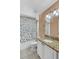 Well-lit bathroom with granite countertop, white cabinets, and shower with colorful curtain at 1906 Chathamoor Dr, Orlando, FL 32835