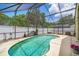 Screened in backyard with sparkling swimming pool, white vinyl fence, and lush landscaping at 1906 Chathamoor Dr, Orlando, FL 32835