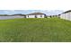 Large backyard with lush green grass, enclosed by a white fence, perfect for outdoor activities and relaxation at 1940 Piedmont Ct, Mascotte, FL 34753