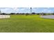 Expansive backyard with lush green grass, a water tower, and a white fence at 1940 Piedmont Ct, Mascotte, FL 34753
