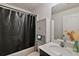 Well-lit bathroom with a vanity, cabinet, and a shower with a black curtain at 1940 Piedmont Ct, Mascotte, FL 34753