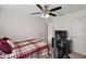 Bright bedroom features a ceiling fan, closet, and a black dresser under the TV at 1940 Piedmont Ct, Mascotte, FL 34753