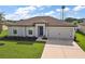 Well-maintained single-story home with manicured front lawn and a two-car garage enhances curb appeal at 1940 Piedmont Ct, Mascotte, FL 34753