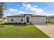 Charming single-story home with a well-manicured lawn and an attached two-car garage at 1940 Piedmont Ct, Mascotte, FL 34753