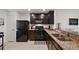 Well-equipped kitchen featuring dark cabinets, granite counters, and modern appliances, perfect for cooking at 1940 Piedmont Ct, Mascotte, FL 34753