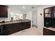 Bright kitchen featuring granite countertops, dark wood cabinetry and views into the dining and living area at 1940 Piedmont Ct, Mascotte, FL 34753