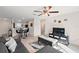 Open-concept living room with modern decor, tile floors, and a seamless flow into the dining area and kitchen at 1940 Piedmont Ct, Mascotte, FL 34753