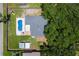 Aerial view of a fenced backyard with an in-ground pool, lawn, and mature trees at 204 Lori Ct, Umatilla, FL 32784