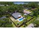 Aerial view of a property featuring a pool, playground and fenced-in backyard surrounded by lush greenery at 204 Lori Ct, Umatilla, FL 32784